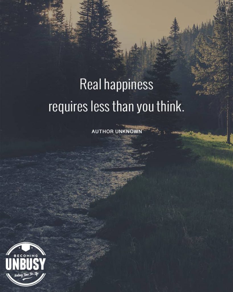 A flowing river in nature with the minimalism quote, "Real happiness requires less than you think."
