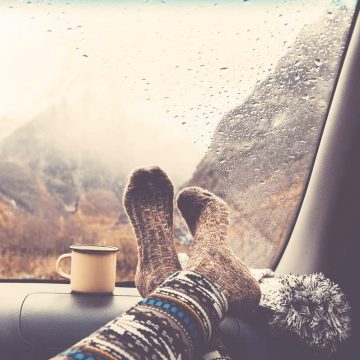 Womans feet resting on a car dashboard as she lives an unbalanced life.