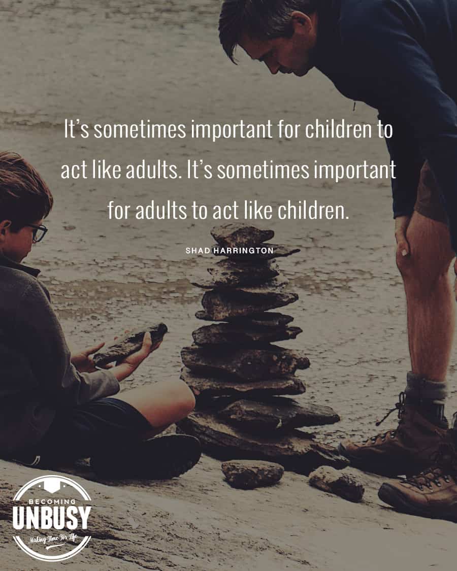 Father and son stacking rocks on the beach with the following quote on top, "It's sometimes important for children to act like adults. It's sometimes important for adults to act like children."