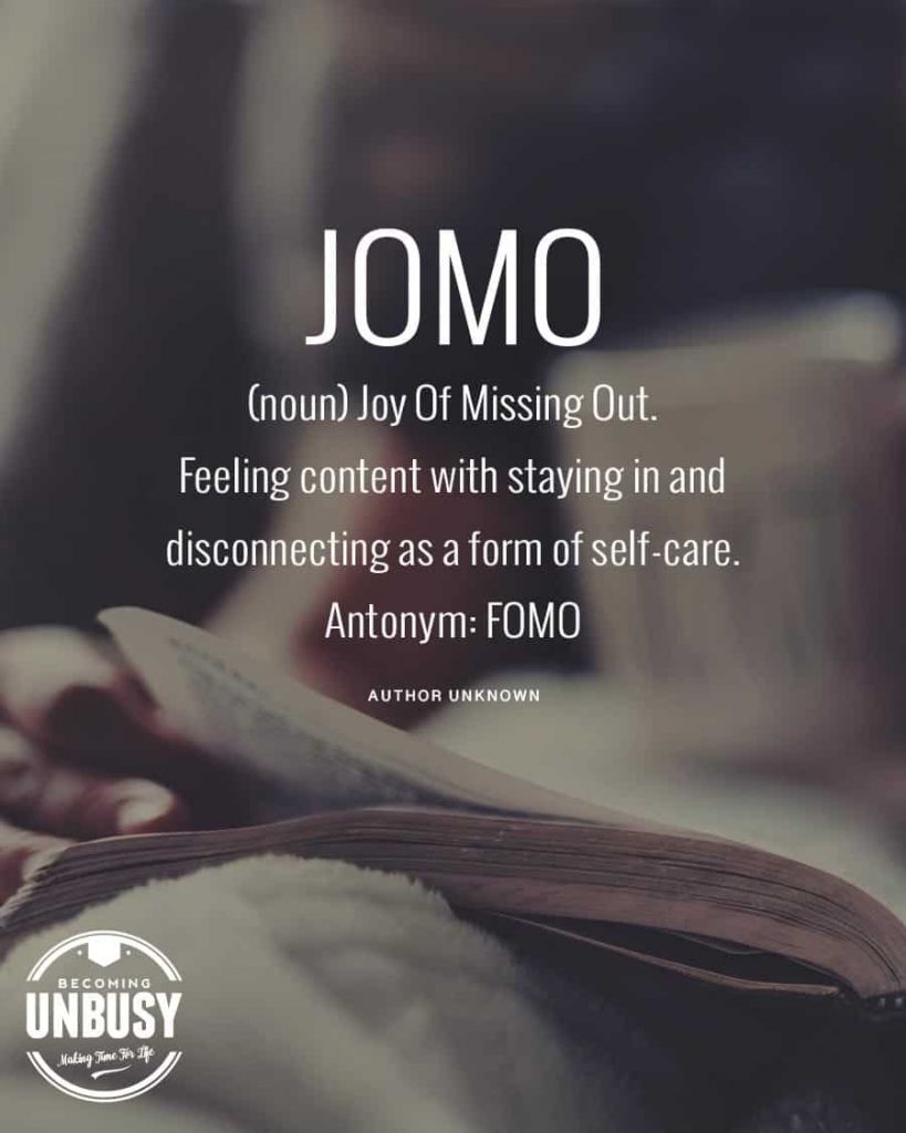 A woman leading a simple life, flipping pages of a book with this text written overtop, "JOMO (noun) Joy Of Missing Out: Feeling content with staying in and disconnecting as a form of self-care. Antonym: FOMO"