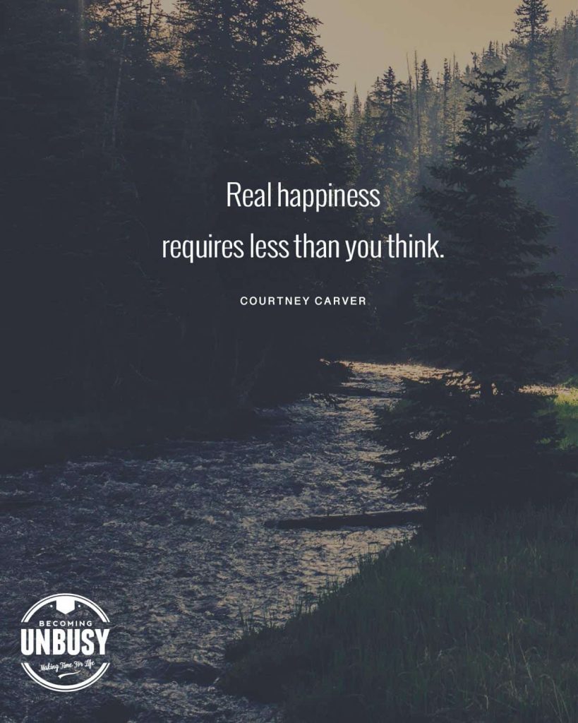 A river at dusk with pine trees surrounding it and a simple life quote written over top reading, "Real happiness requires less than you think."