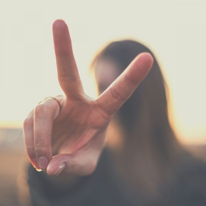 Woman making a peace sign with her hands.