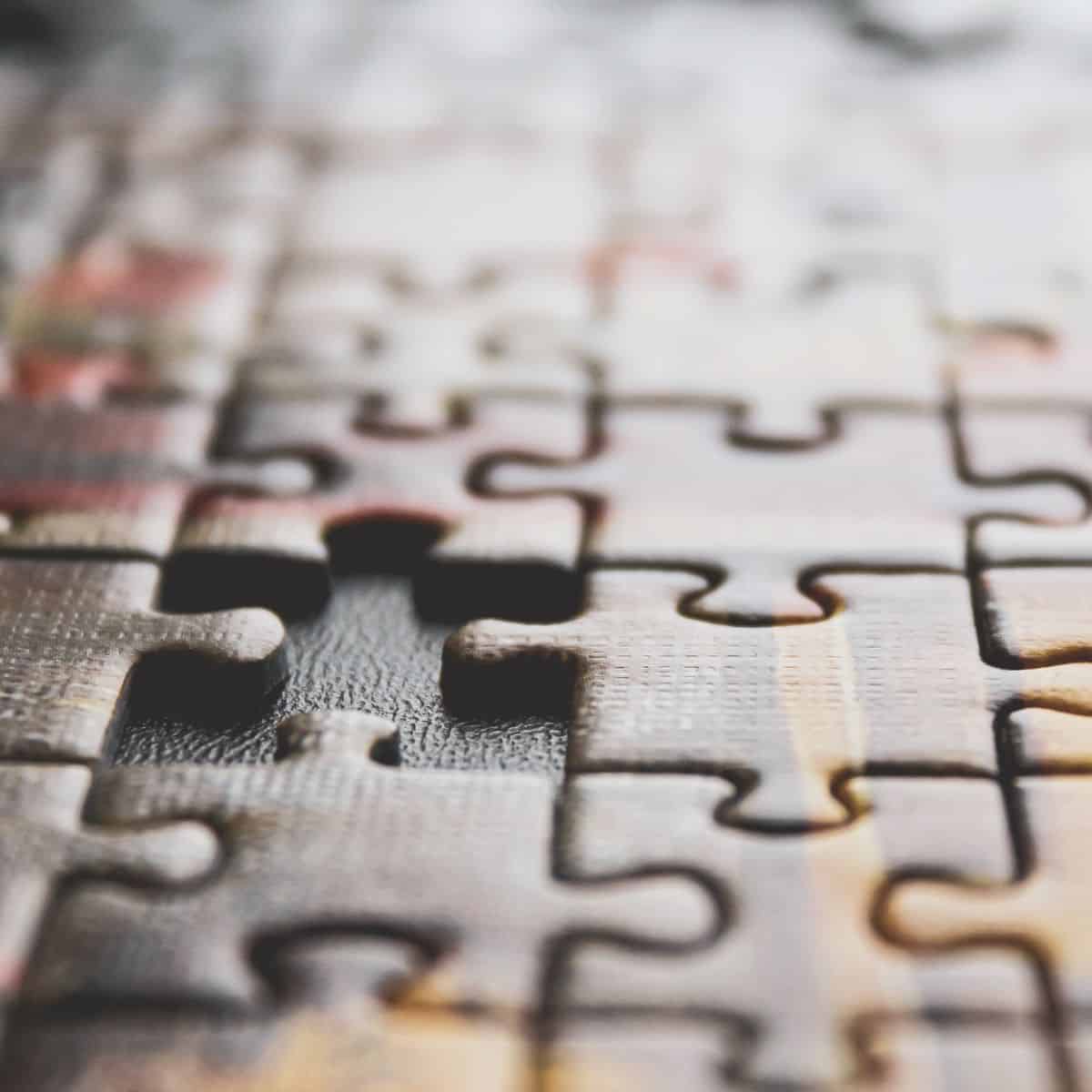 A close-up of a jigsaw puzzle with a single piece missing.