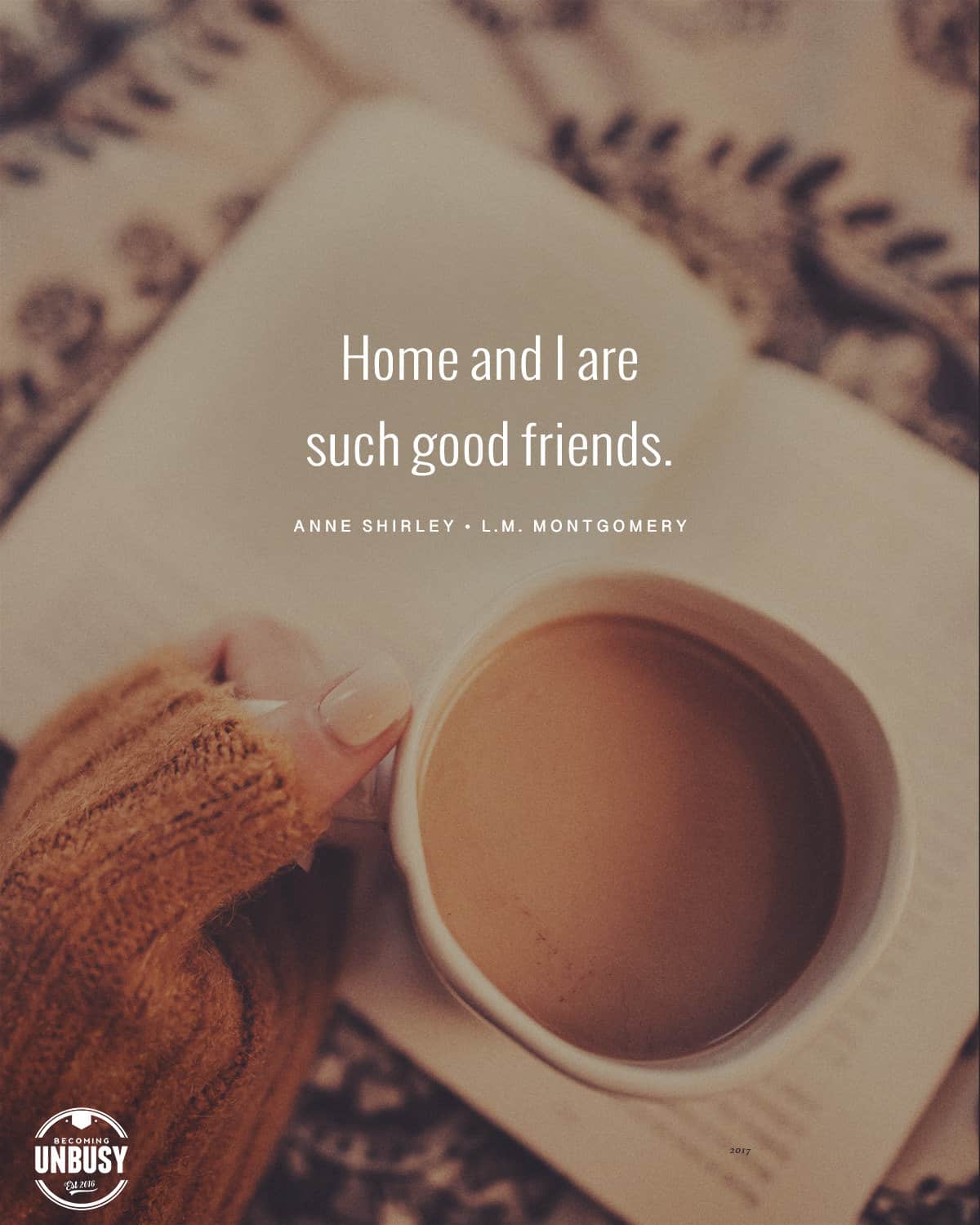 The following fall bucket list quote written over a photo of a woman holding a hot cup of coffee while wearing a chunky autumn sweater, "Home and I are such good friends. — Anne Shirley."