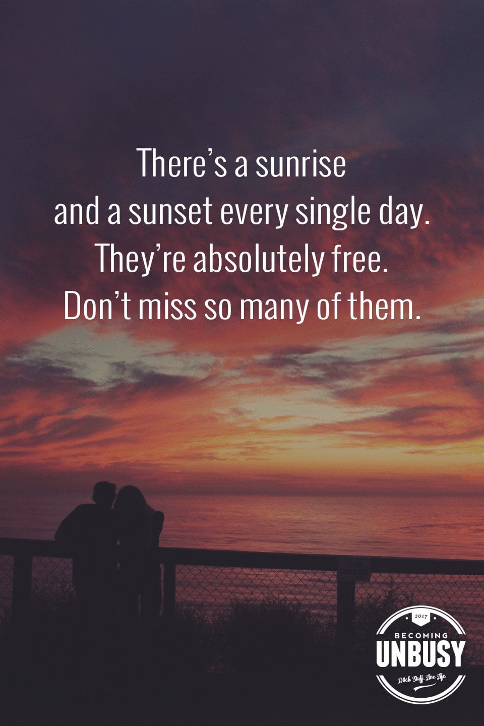 The following winter self-care quote over a photo of a couple at a fence watching a sunset, "There's a sunset every single day. The show is absolutely free. Don't miss so many of them."